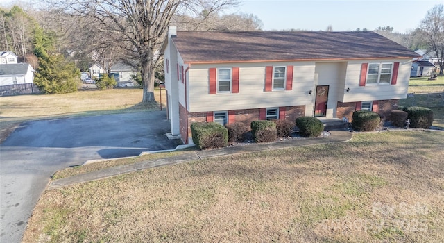 raised ranch featuring a front lawn