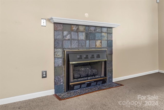 interior details featuring carpet floors and a tile fireplace