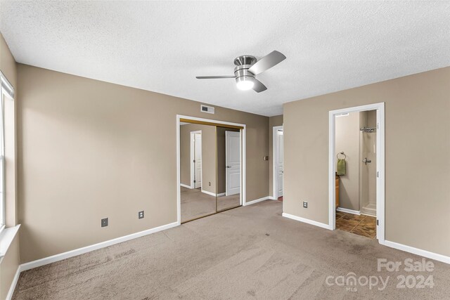 unfurnished bedroom featuring carpet flooring, ceiling fan, a closet, and a textured ceiling