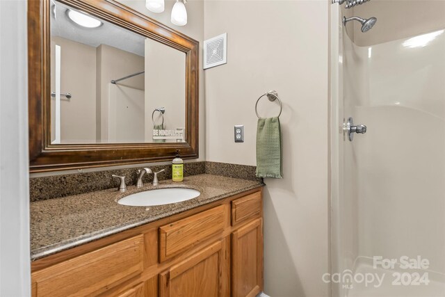 bathroom with a shower and vanity