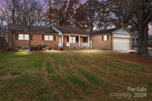 ranch-style house with a porch, a garage, and a front yard