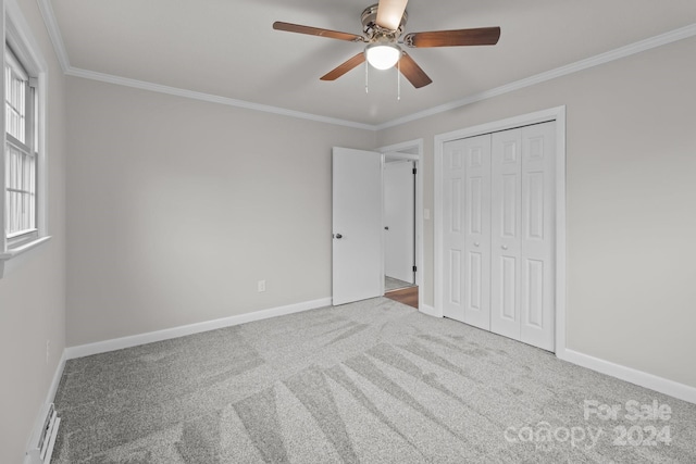 unfurnished bedroom with baseboard heating, ceiling fan, carpet floors, and ornamental molding