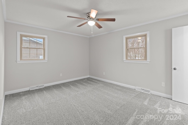 carpeted spare room featuring ceiling fan and crown molding