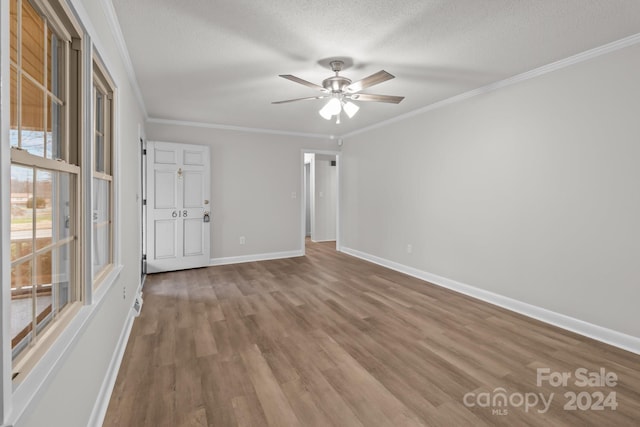 spare room with ceiling fan, wood-type flooring, a textured ceiling, and ornamental molding