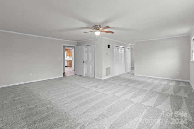 interior space with light carpet, a textured ceiling, ceiling fan, and ornamental molding