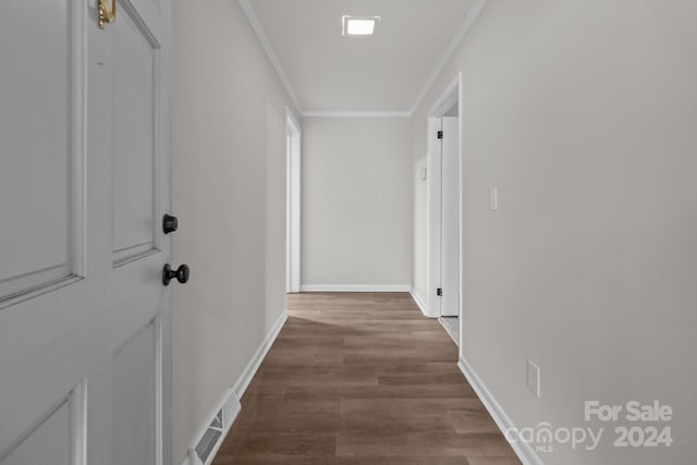 hallway with wood-type flooring and ornamental molding