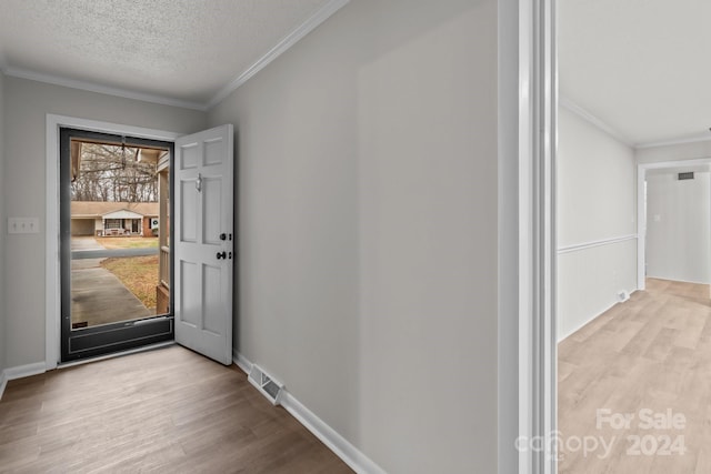 foyer featuring crown molding, a textured ceiling, and light hardwood / wood-style flooring