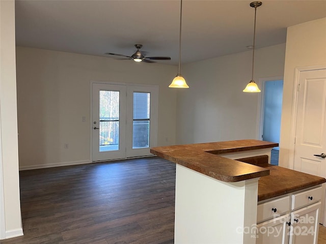 kitchen with a center island, white cabinets, hanging light fixtures, ceiling fan, and dark hardwood / wood-style flooring