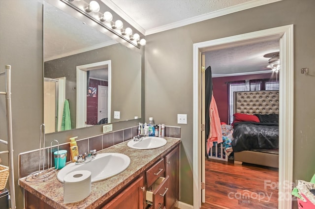 bathroom featuring vanity, a textured ceiling, hardwood / wood-style flooring, and ornamental molding