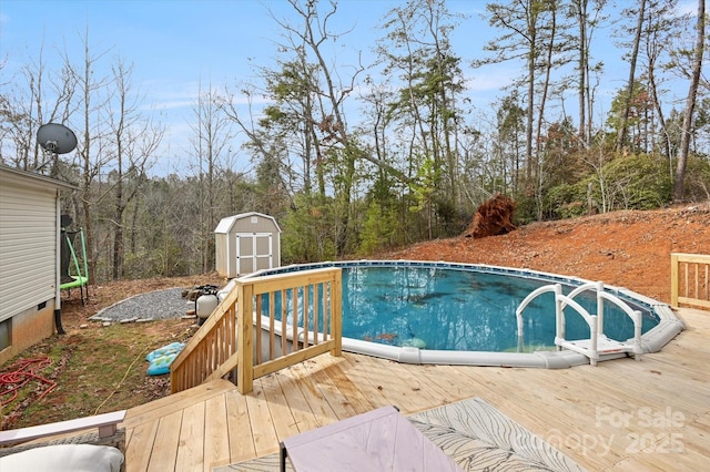 view of swimming pool with a shed and a wooden deck