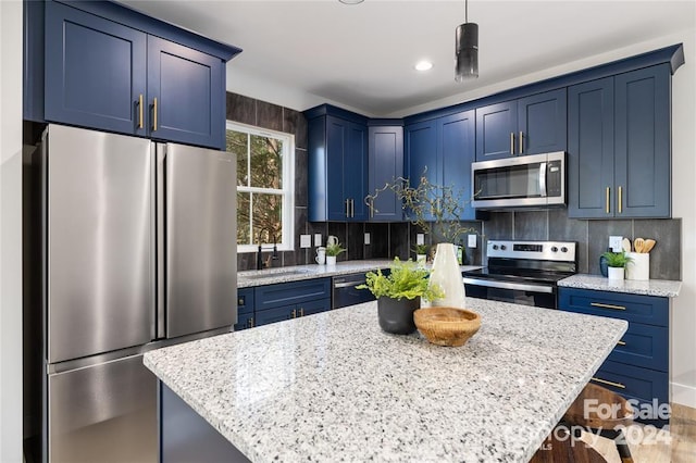 kitchen featuring blue cabinetry, sink, decorative light fixtures, and appliances with stainless steel finishes