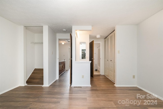 unfurnished bedroom featuring a textured ceiling and dark hardwood / wood-style floors