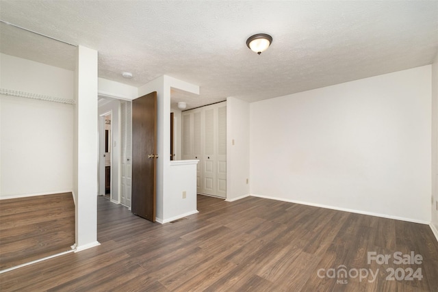 interior space featuring a textured ceiling and dark wood-type flooring