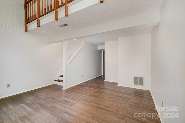 basement with dark hardwood / wood-style flooring and a textured ceiling