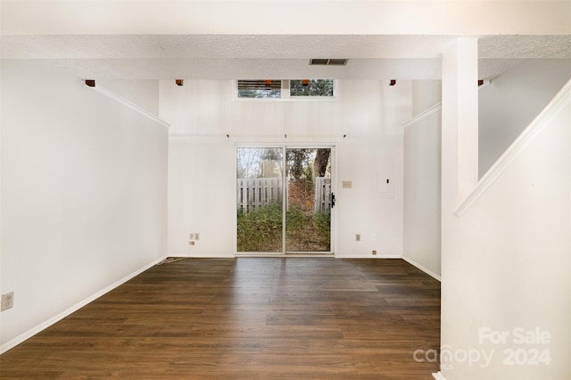 unfurnished room with dark hardwood / wood-style flooring and a textured ceiling