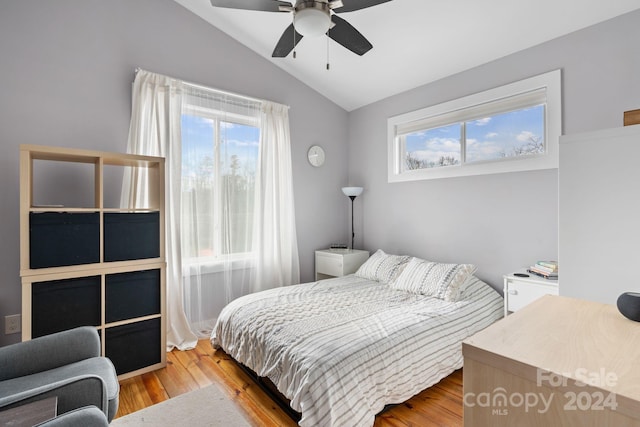 bedroom with multiple windows, ceiling fan, light hardwood / wood-style flooring, and vaulted ceiling