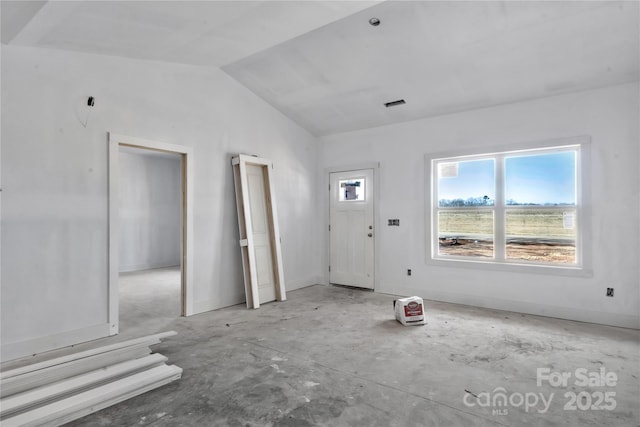 foyer featuring vaulted ceiling and baseboards