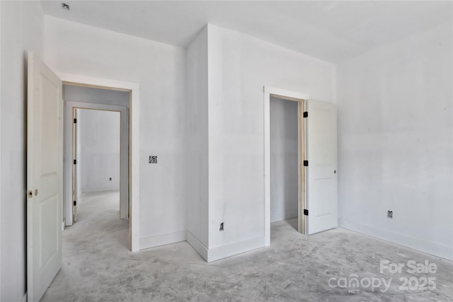 unfurnished bedroom featuring baseboards and unfinished concrete floors