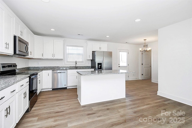 kitchen featuring white cabinets, a kitchen island, stainless steel appliances, and a wealth of natural light