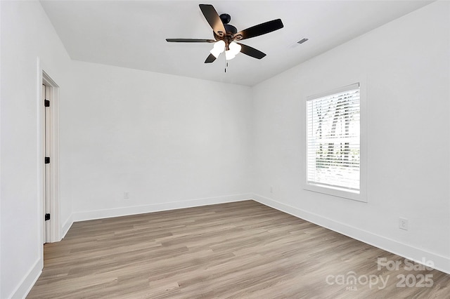 unfurnished room with visible vents, ceiling fan, light wood-type flooring, and baseboards