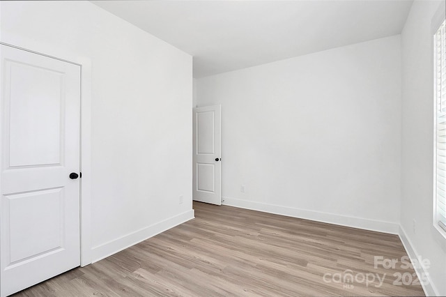 unfurnished bedroom with baseboards and light wood-type flooring