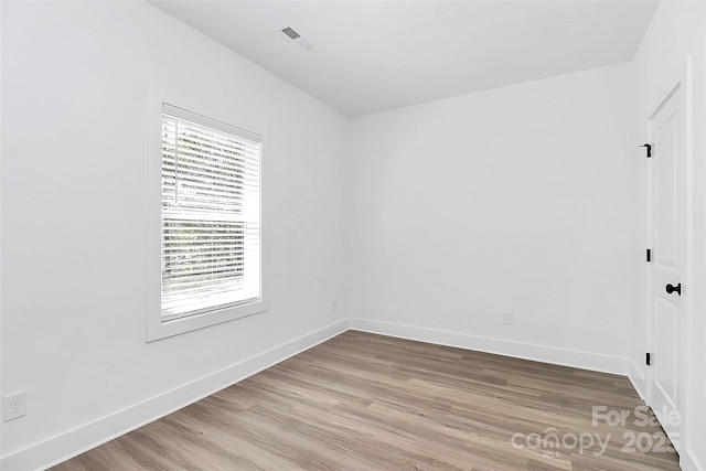 unfurnished room featuring baseboards and light wood-type flooring