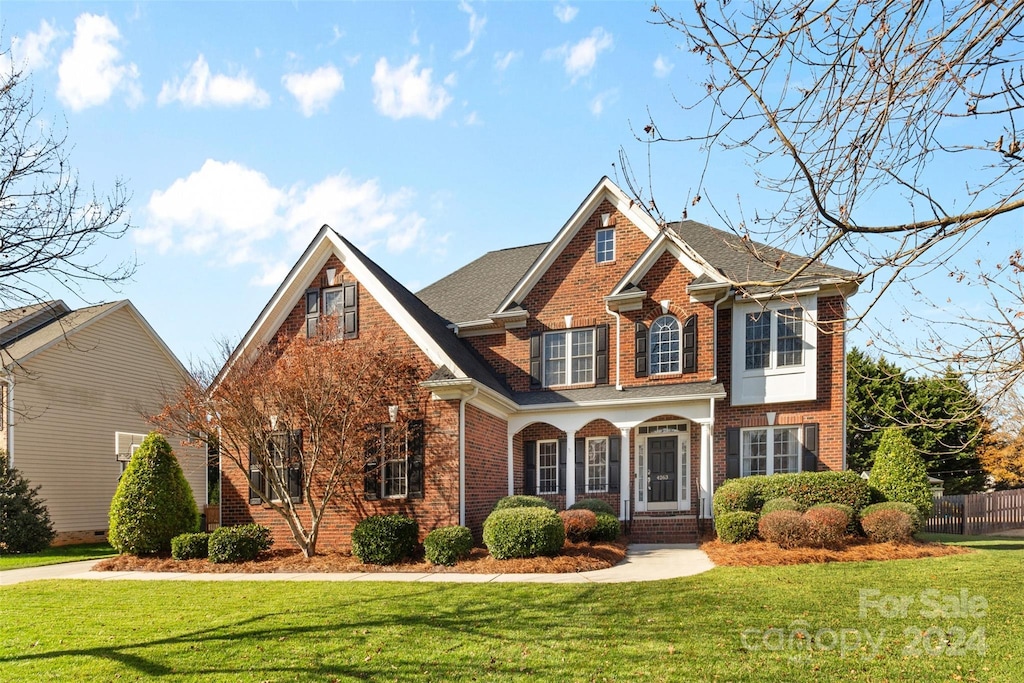 view of front of home with a porch and a front lawn