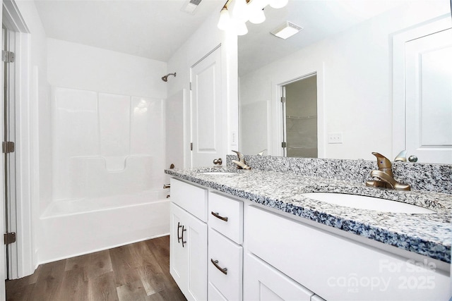 bathroom with vanity, hardwood / wood-style floors, and bathtub / shower combination