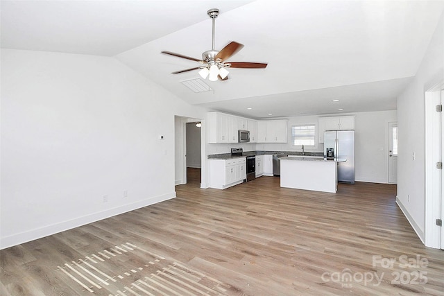 kitchen featuring stainless steel appliances, a kitchen island, white cabinetry, open floor plan, and light wood finished floors