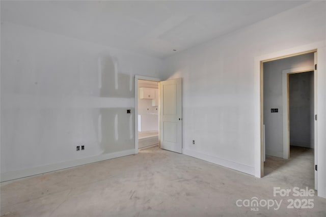 unfurnished bedroom with concrete floors and baseboards