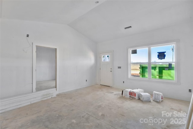 entrance foyer with vaulted ceiling and concrete floors