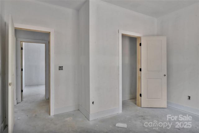 unfurnished bedroom featuring baseboards and unfinished concrete floors