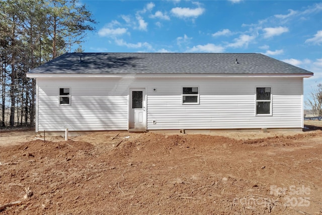 rear view of property featuring a shingled roof