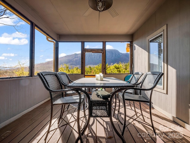 sunroom with a mountain view and ceiling fan