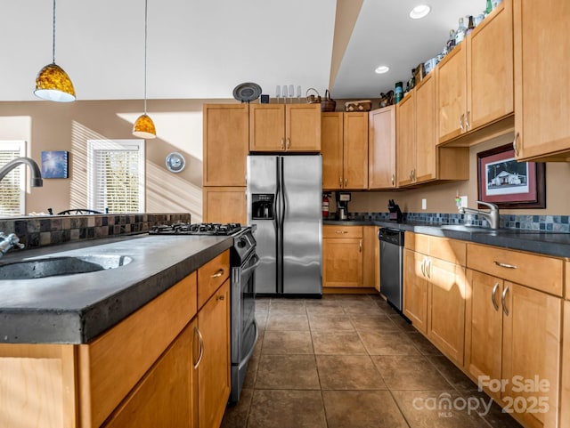 kitchen featuring decorative light fixtures, stainless steel appliances, dark tile patterned floors, and sink