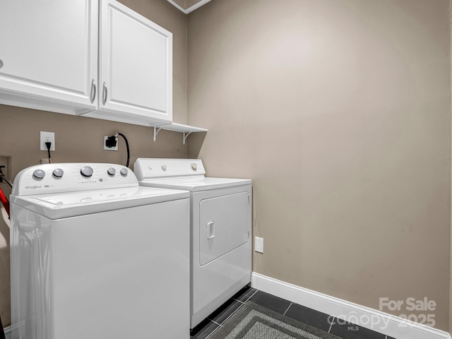 laundry room with dark tile patterned flooring, cabinets, and separate washer and dryer