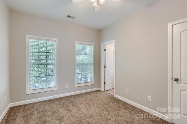 carpeted spare room featuring ceiling fan