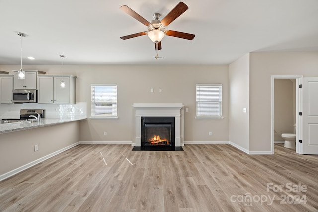 unfurnished living room featuring ceiling fan and light hardwood / wood-style flooring