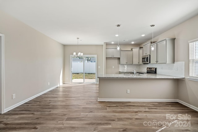 kitchen featuring appliances with stainless steel finishes, hardwood / wood-style flooring, a healthy amount of sunlight, and gray cabinetry