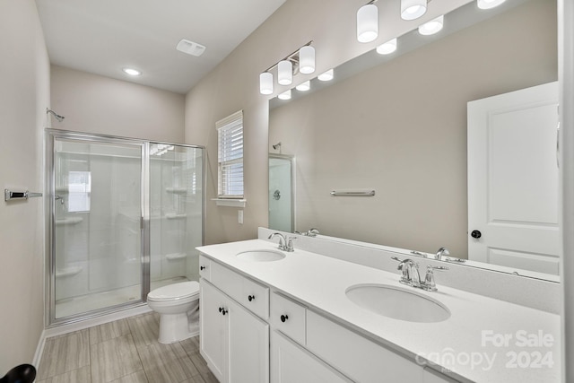 bathroom with tile patterned flooring, toilet, vanity, and walk in shower