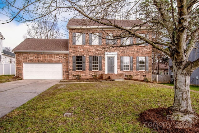 colonial inspired home featuring a garage and a front lawn