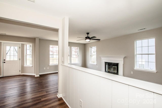 unfurnished living room featuring dark hardwood / wood-style floors and ceiling fan