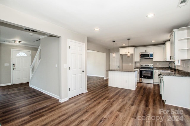 kitchen featuring dark hardwood / wood-style floors, a kitchen island, stainless steel appliances, and decorative light fixtures