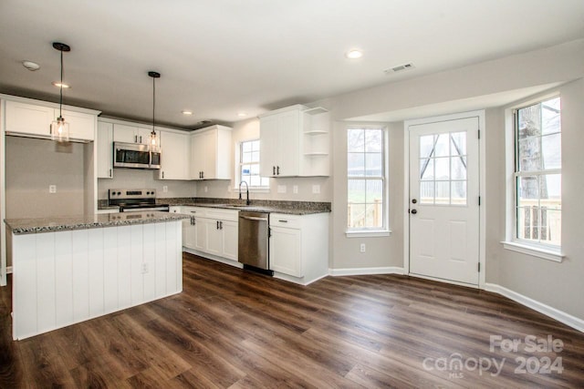 kitchen with dark hardwood / wood-style flooring, stainless steel appliances, white cabinetry, and a wealth of natural light