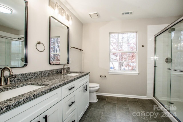 bathroom with tile patterned floors, vanity, toilet, and an enclosed shower