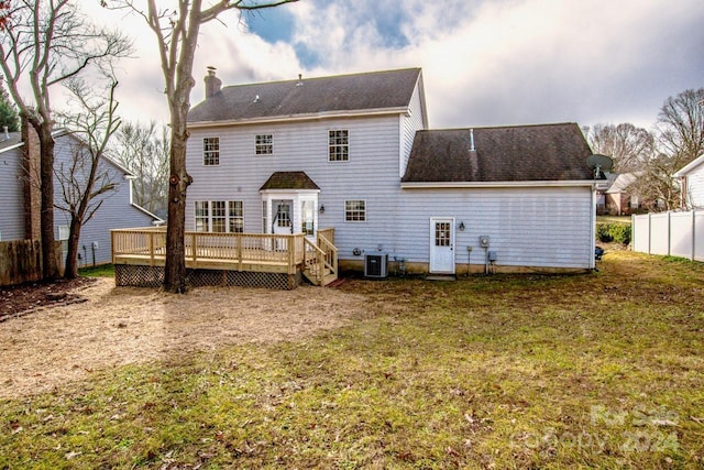 rear view of house with a deck, central AC unit, and a lawn