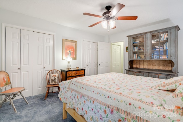 carpeted bedroom with ceiling fan and multiple closets