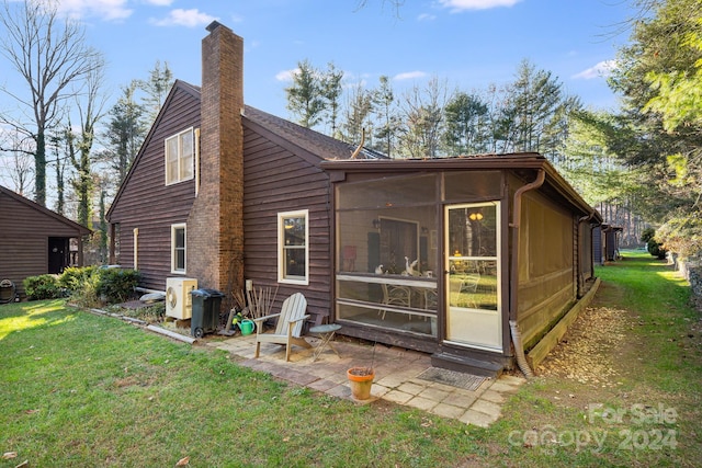 rear view of property with ac unit, a patio, a lawn, and a sunroom