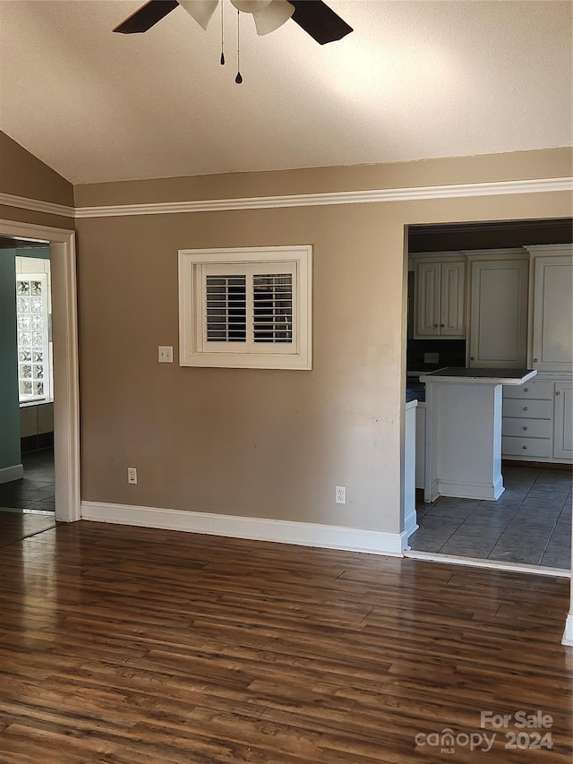 unfurnished living room featuring ceiling fan, dark wood-type flooring, crown molding, a textured ceiling, and lofted ceiling