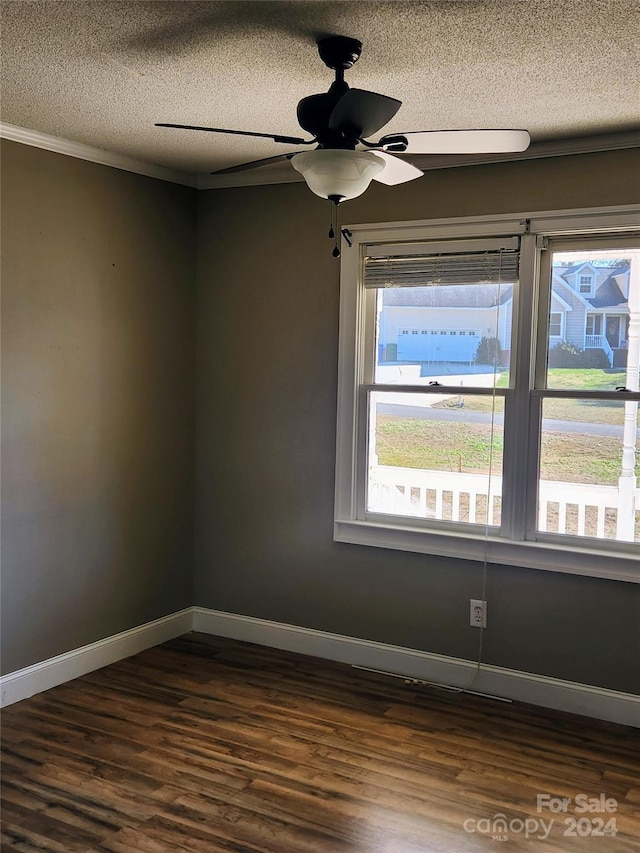 empty room featuring dark hardwood / wood-style flooring, ceiling fan, plenty of natural light, and a textured ceiling